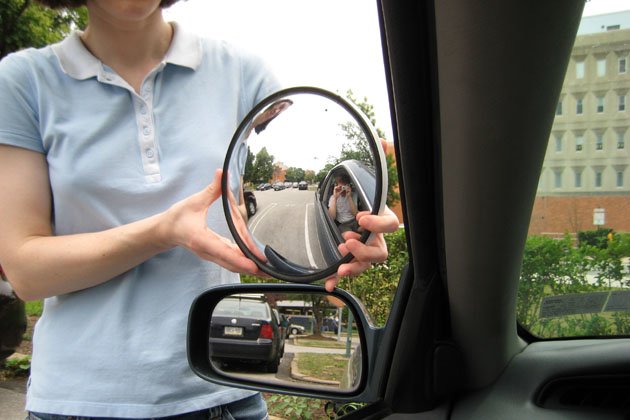 Der seitenspiegel eines autos mit der spiegelung eines autos darin.
