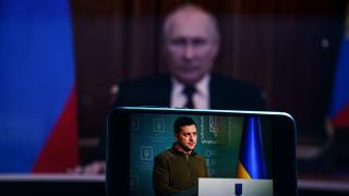 Bildschirm mit Selenskyj, dahinter, unscharf, Putin