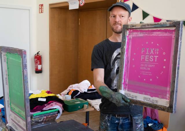 Ein Mann hält eine rosa Druckvorlage zum Fixfest für Siebdruck.