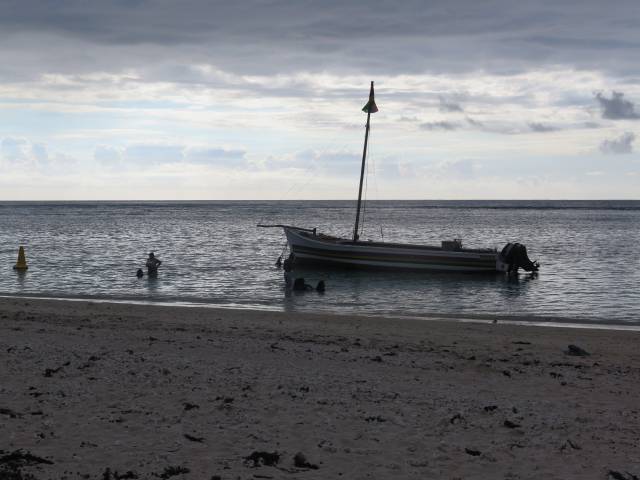 Ein kleines Boot unmittelbar vor einem Sandstrand