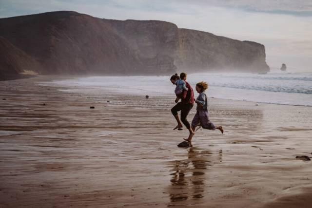 Familie rennt am Strand