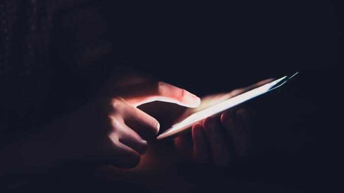 Hände am Smartphone im Dunkeln