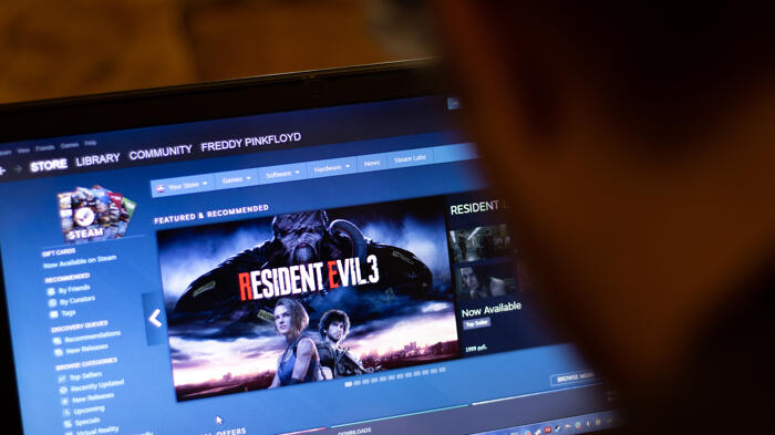 Mann schaut auf Laptop mit Steam