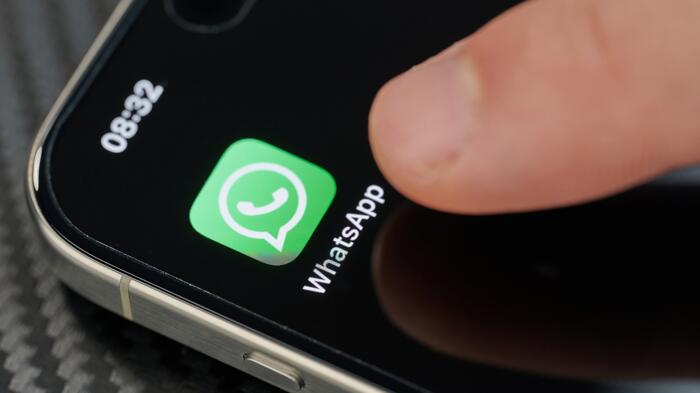 Finger zeigt auf Whatsapp-App auf dem Smartphone-Bildschirm