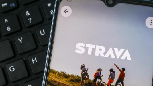 Strava-Startbildschirm auf einem Smartphone, das auf einer Tastatur liegt