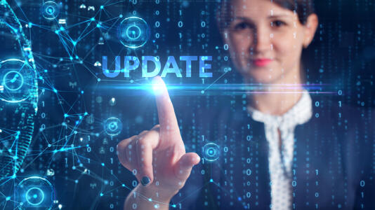 Eine Frau drück einen symbolischen Updateknopf.