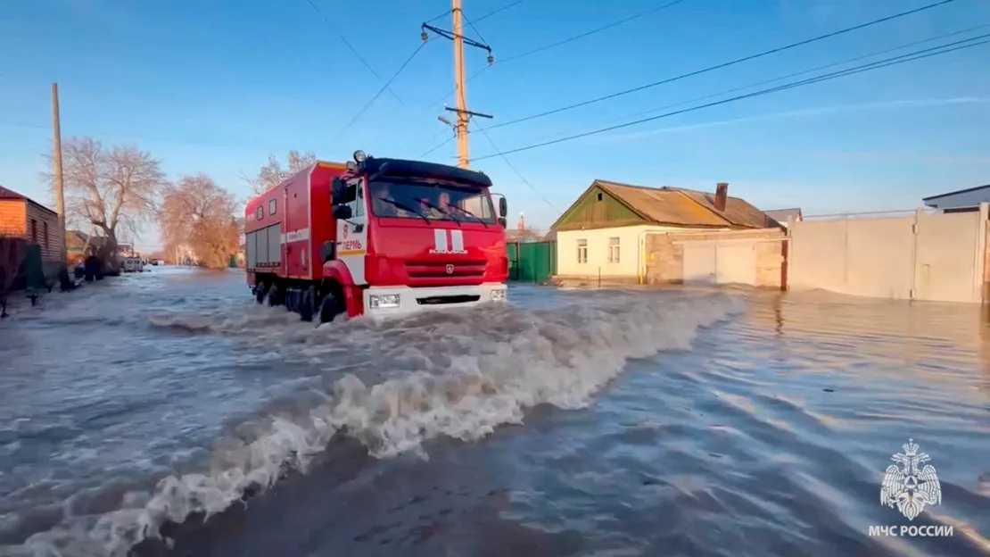 Rettungskräfte fahren durch überflutetes Wohngebiet in der Stadt Orsk, Russland,