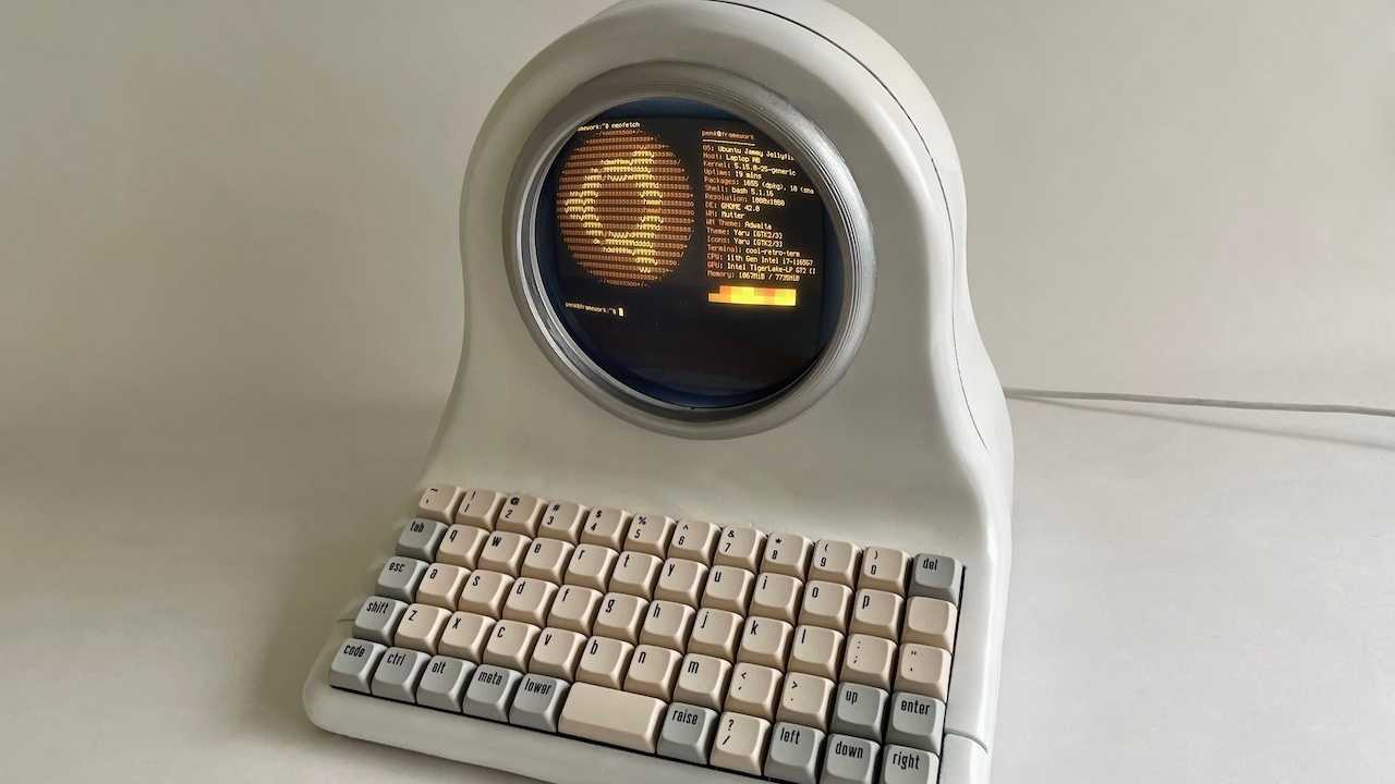 Weißer Computer mit rundem Bildschirm und ortholinearer Tastatur.