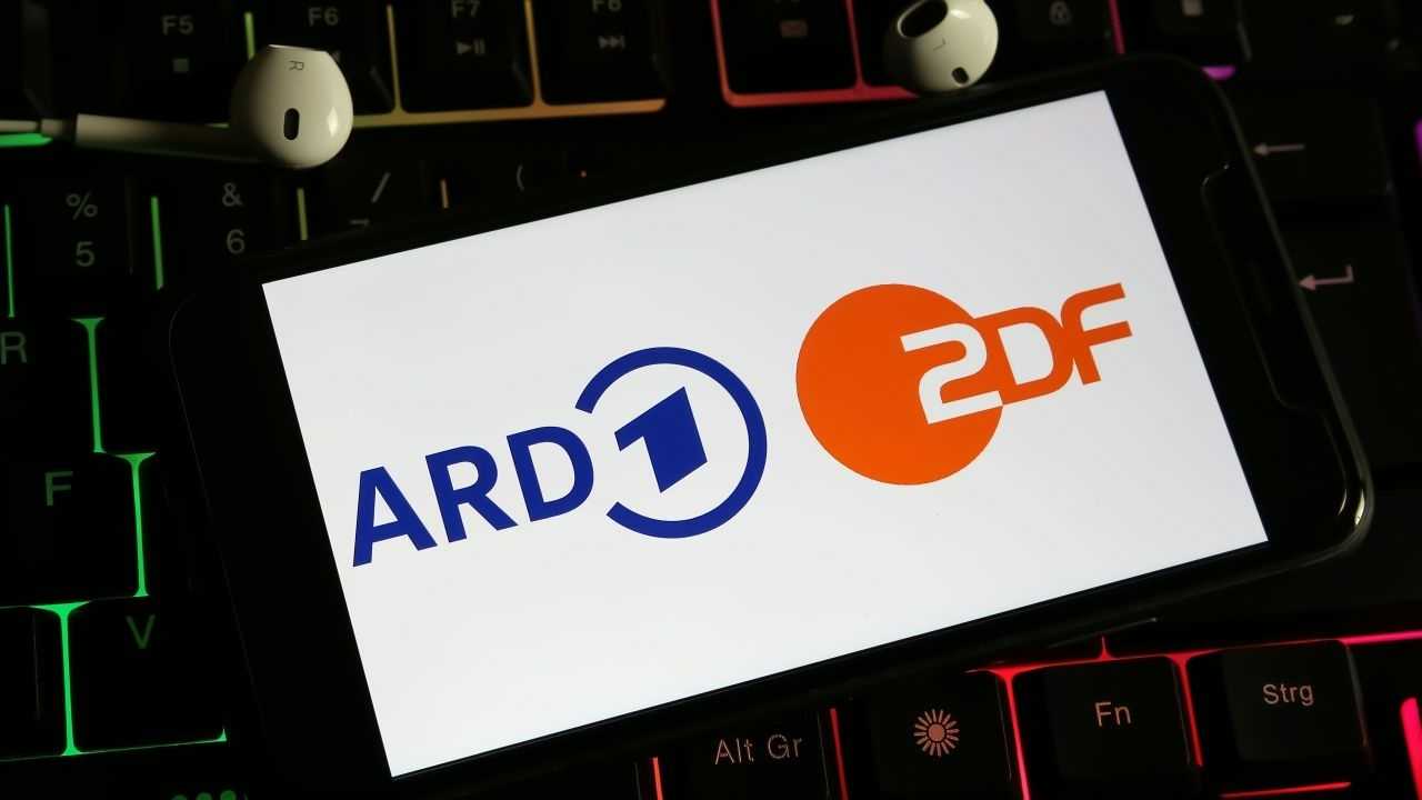 ARD und ZDF-Signen auf einer Karte, die auf einem Laptop liegt