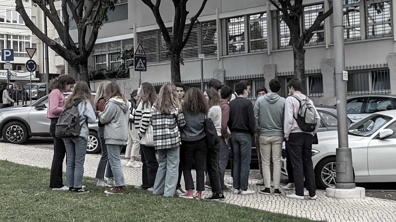 Eine Gruppe Jugendlicher vor einer Schule