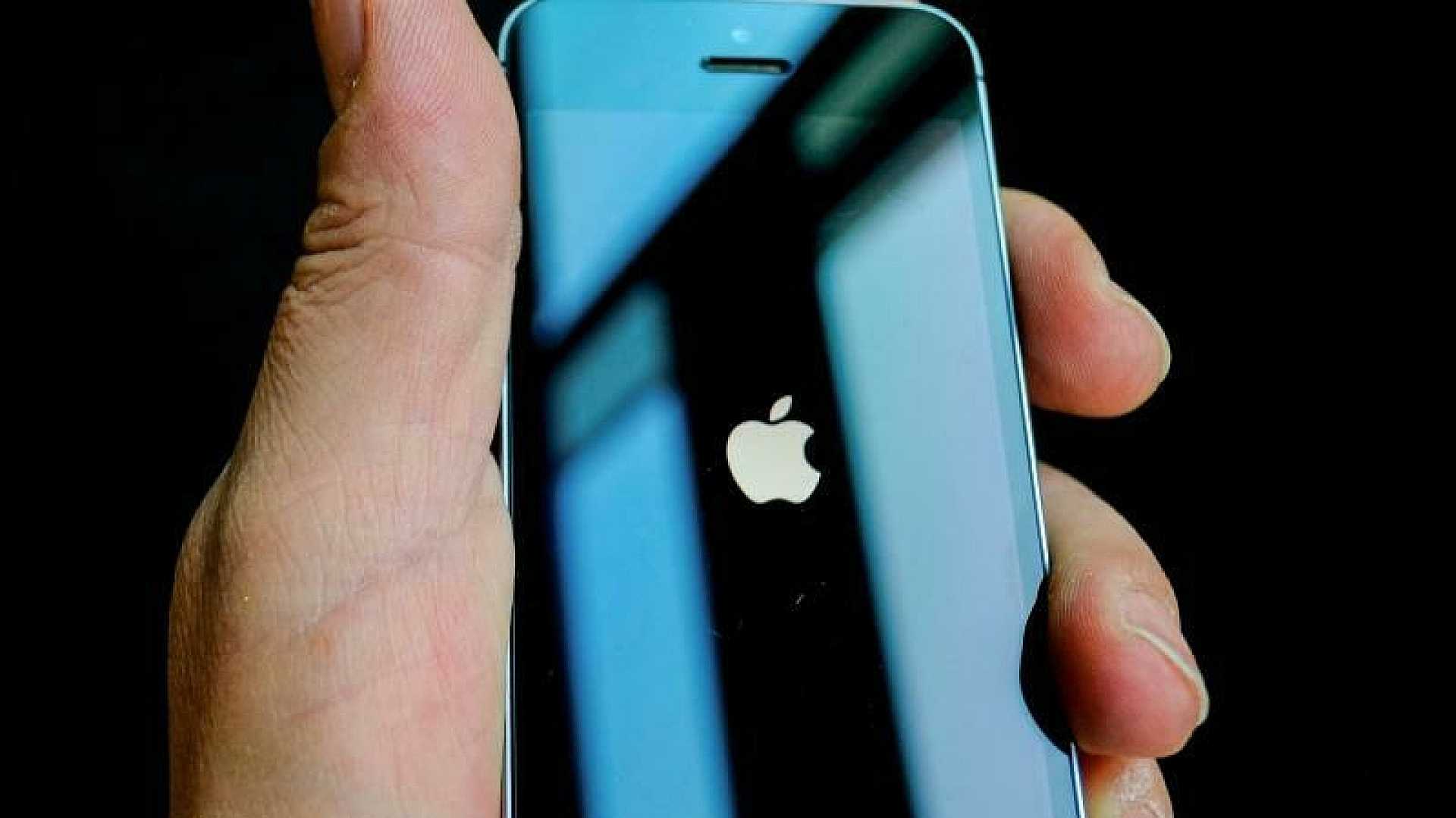 Ein in der Hand gehaltenes iPhone zeigt das Apple-Logo