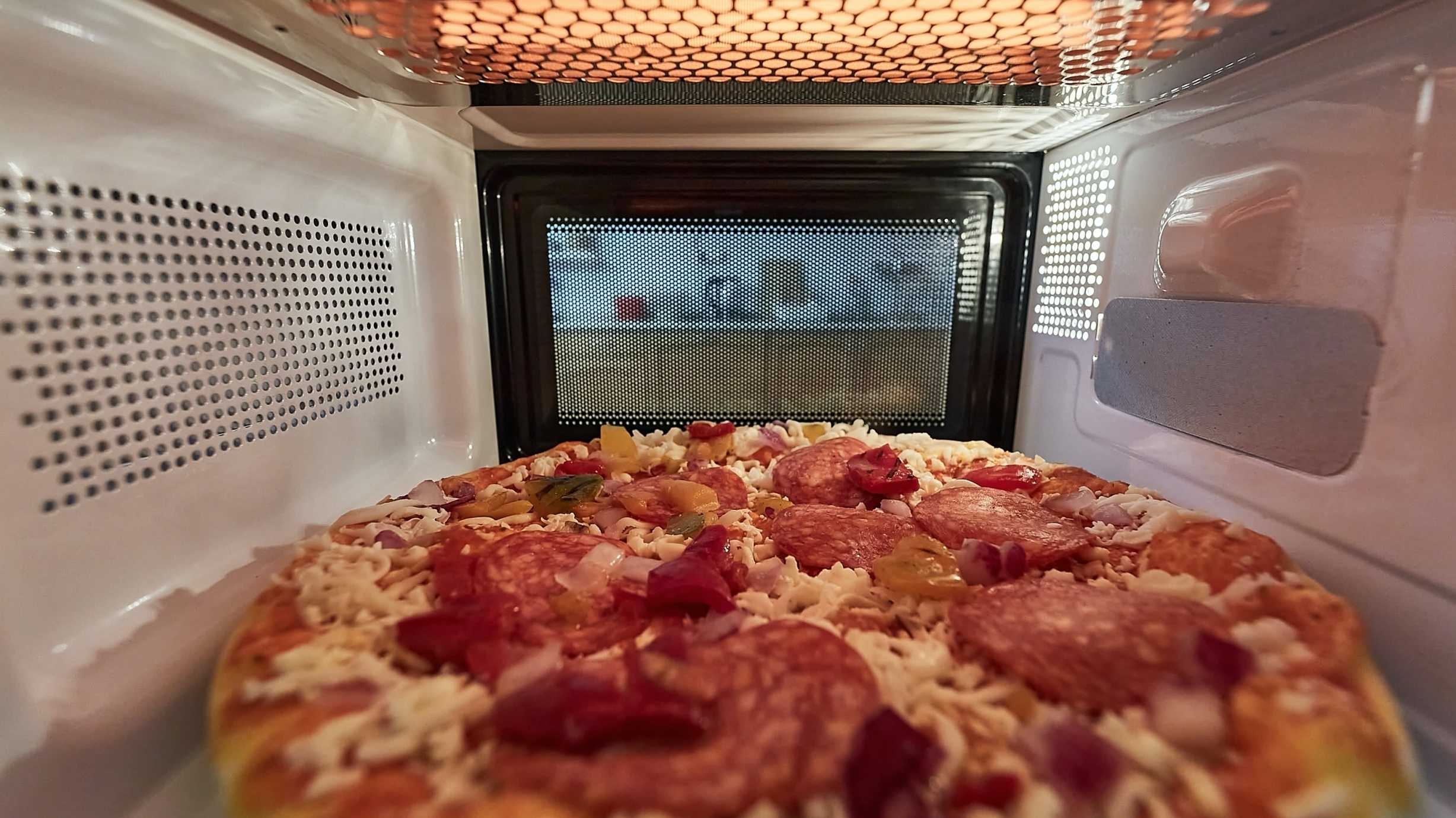 Tiefkühlpizza in einer Mikrowelle von innen