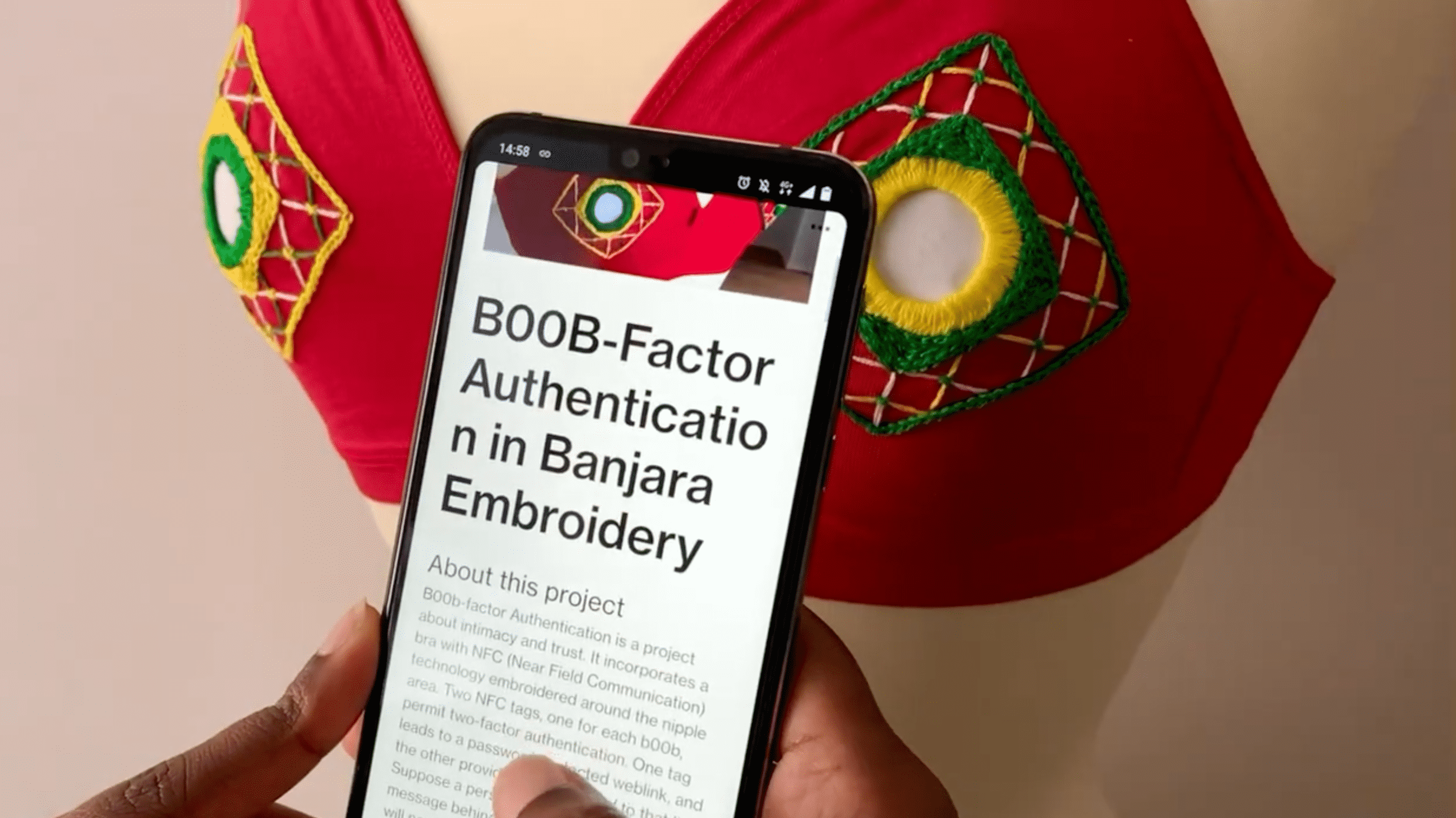 Ein Smartphone mit dem Artikel "B00b-Factor Authentication" vor einem roten BH mit Stickereien und NFC-Tags.