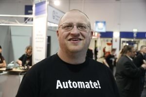 Das Foto zeigt den Autor auf dem LinuxTag 2013, auf dem IS24 diverse Open-Source-Projekte rund um die Automatisierung im Rechenzentrum vorstellte. Das Motto &quot;Automate!&quot; steht für Einstellung zum Thema DevOps.