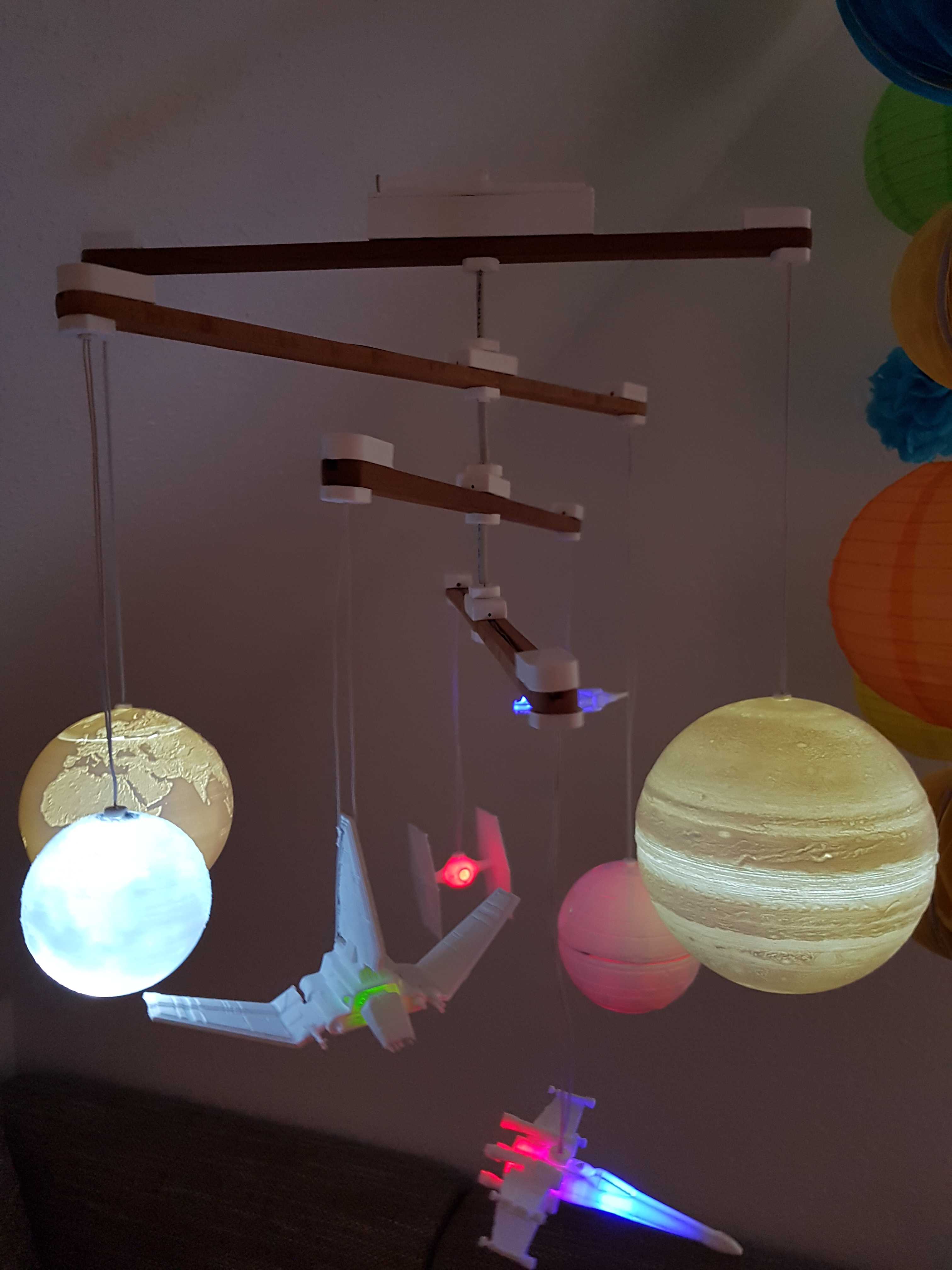 Mobile mit beleuchteten Raumschiffen und Planeten