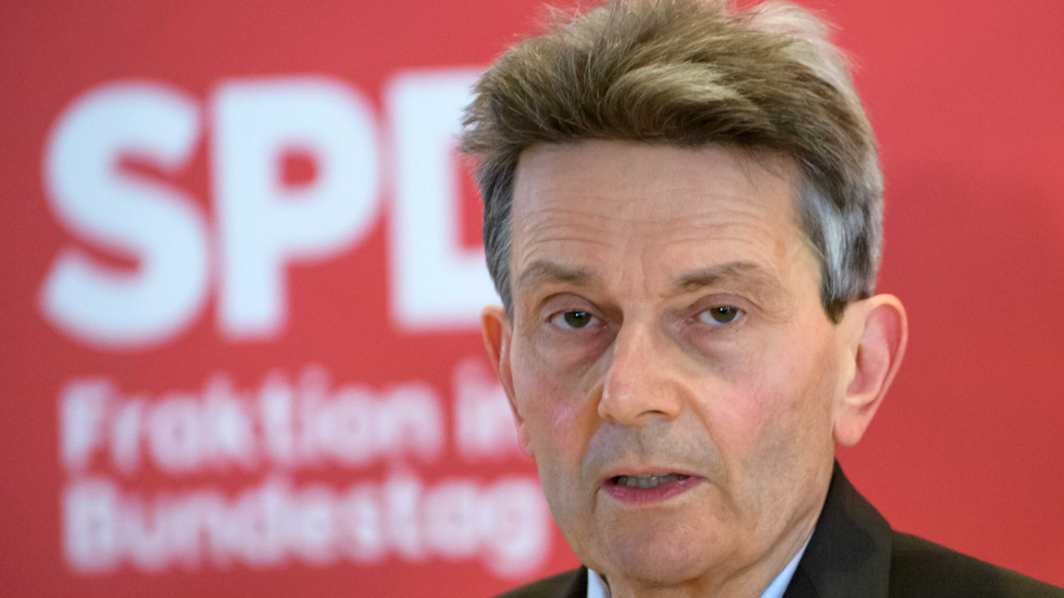 Rolf Mützenich vor SPD-Logo auf rotem Grund