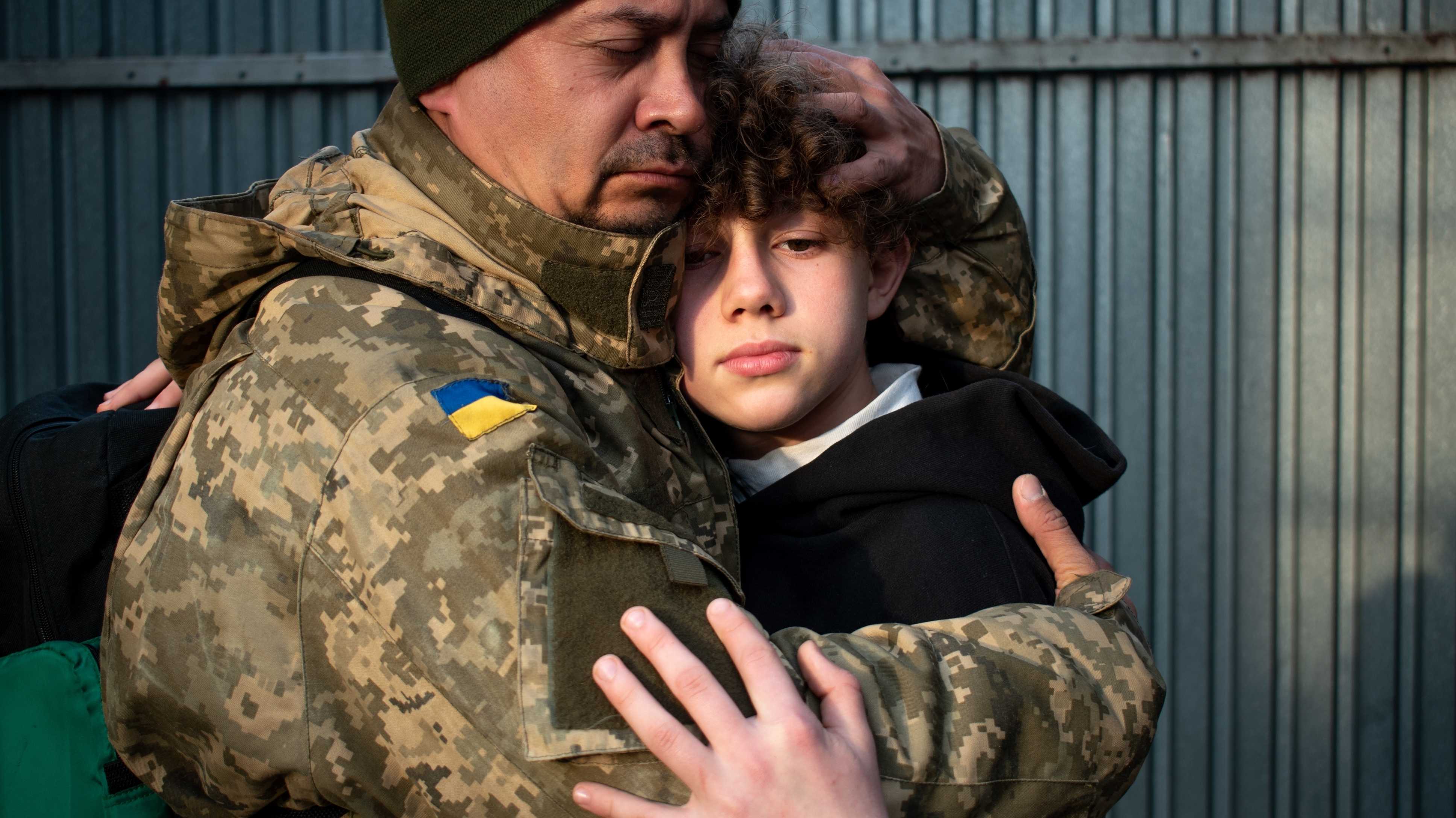 Ukrainischer Soldat umarmt Jugendlichen