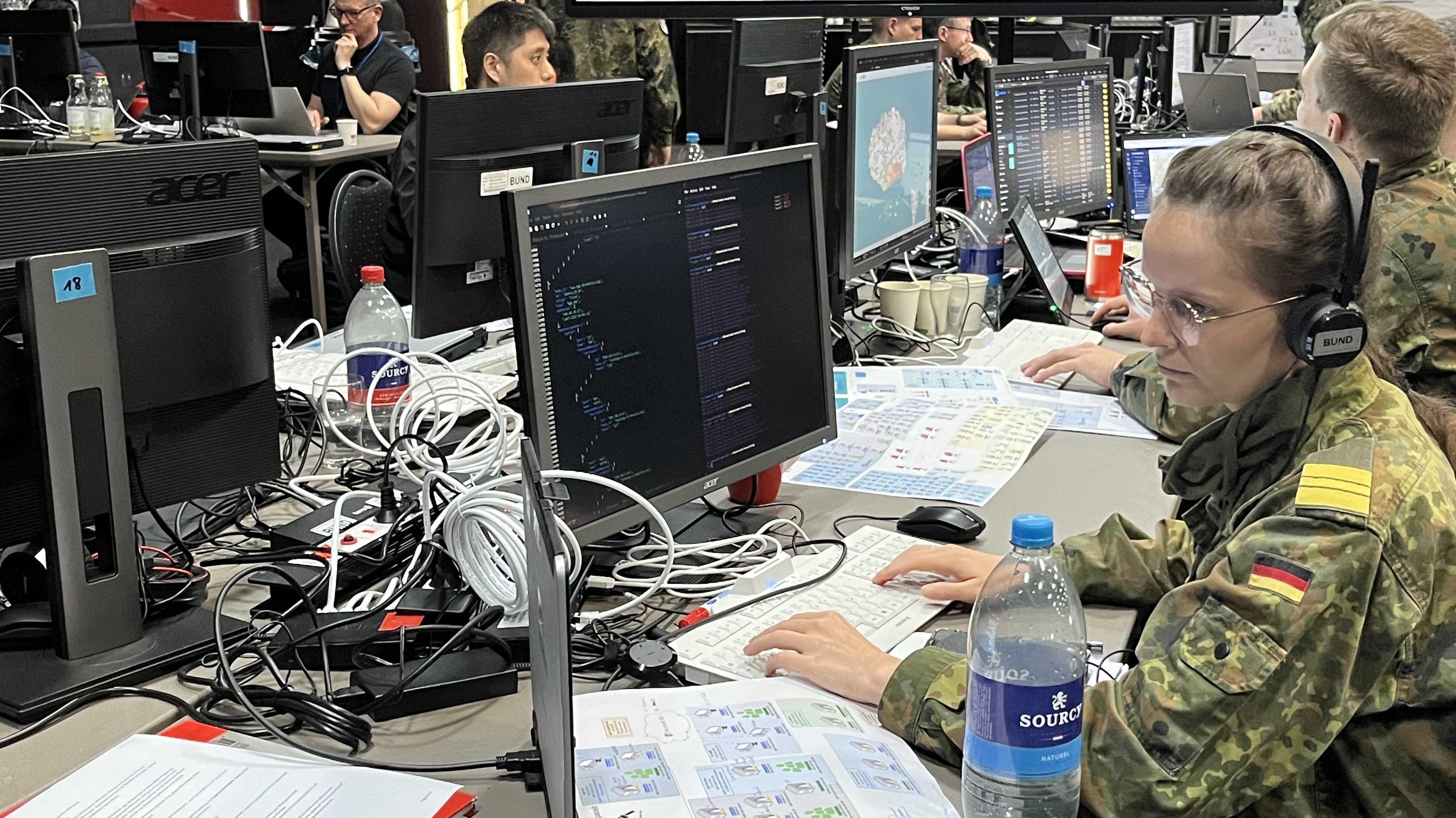 Cybersoldaten in Uniform an Rechnern