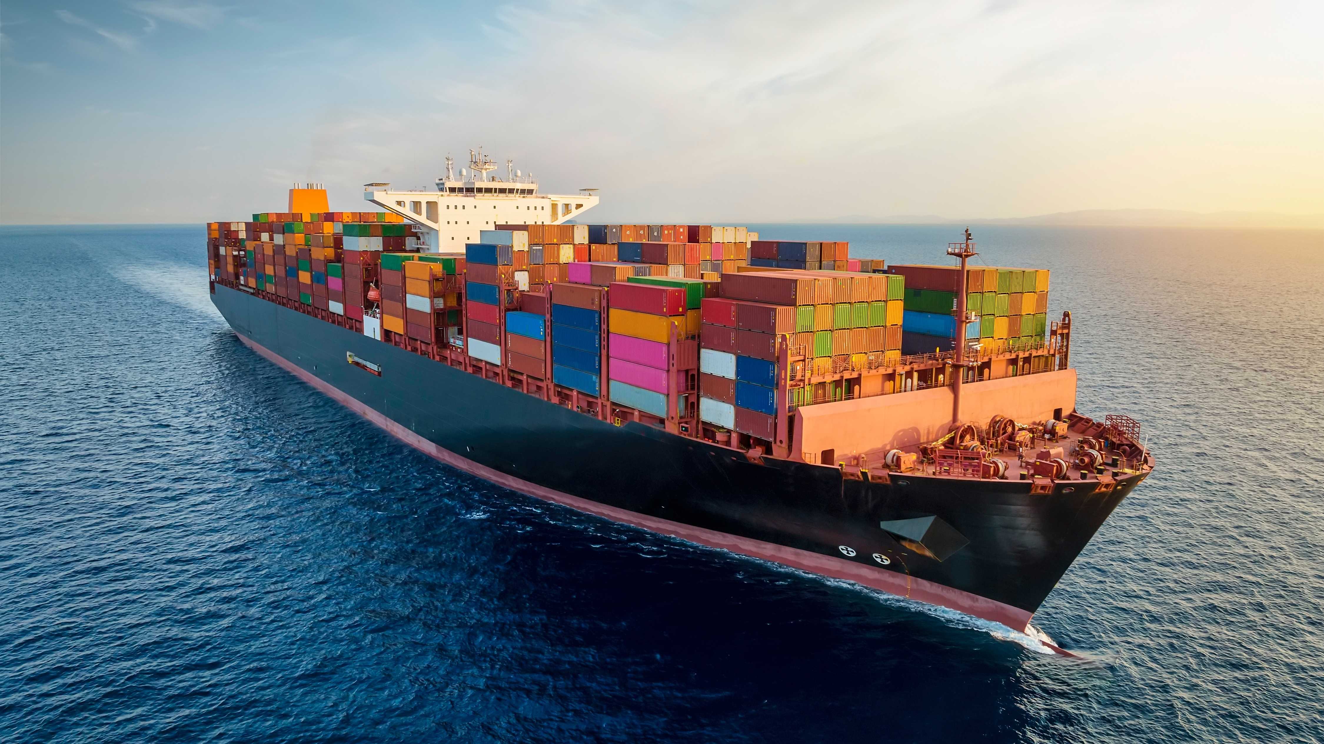 Luftbild eines großen Containerfrachtschiffs, das über offene Ozeane fährt