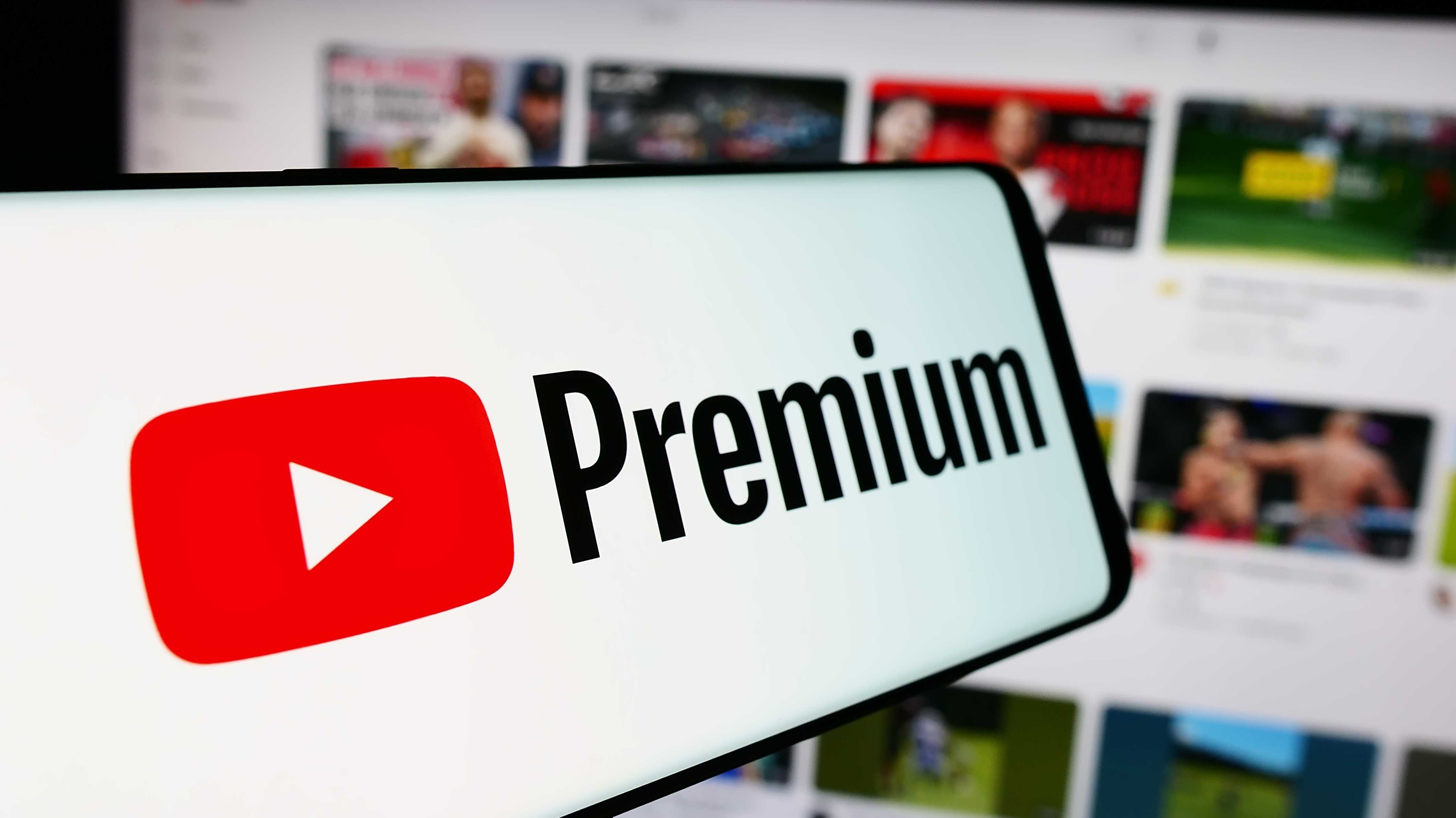Handy mit Logo von Video-Streaming-Abonnement-Service YouTube Premium vor der Business-Website.