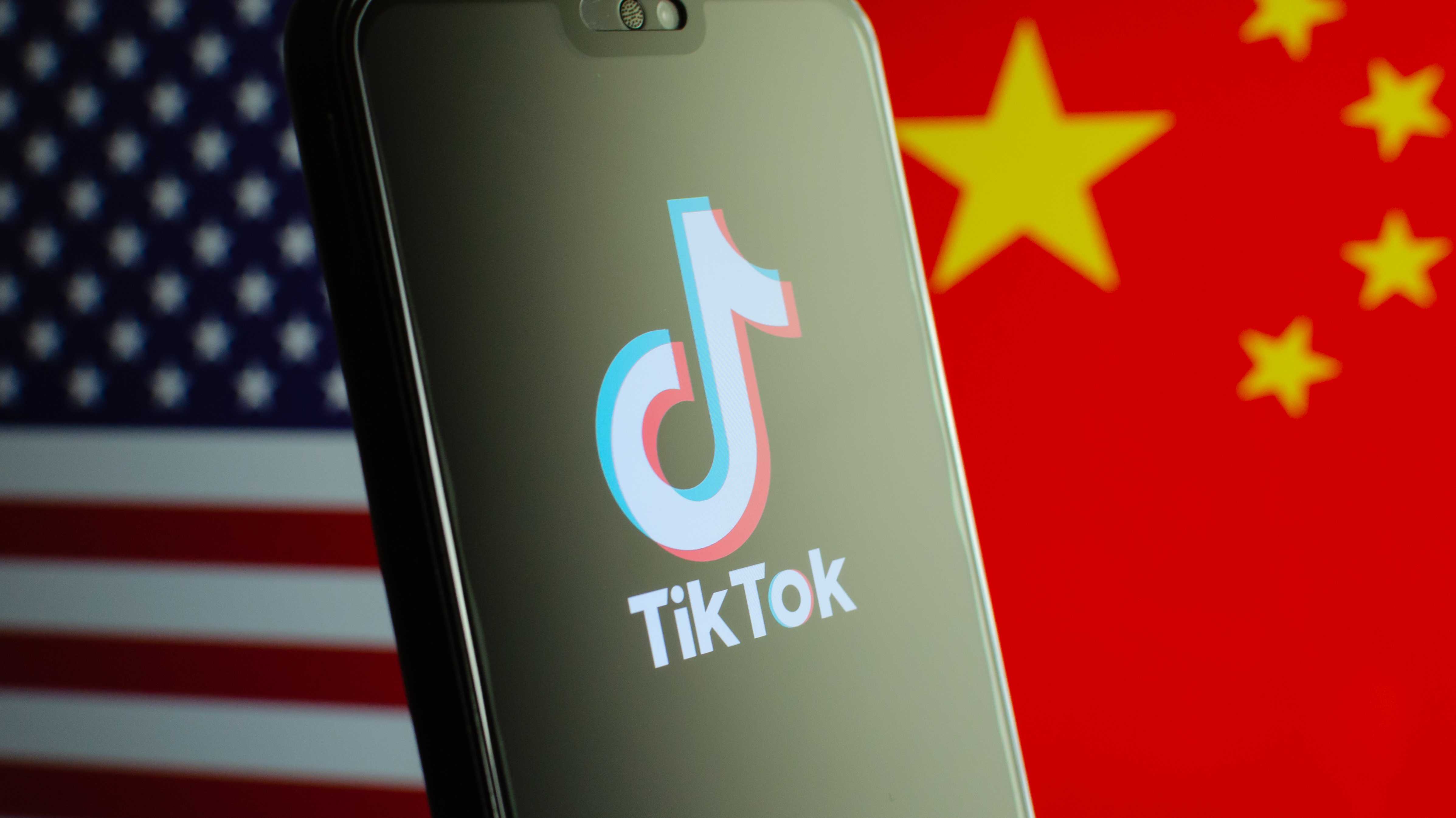 TikTok-Logo vor den Flaggen der USA und Chinas
