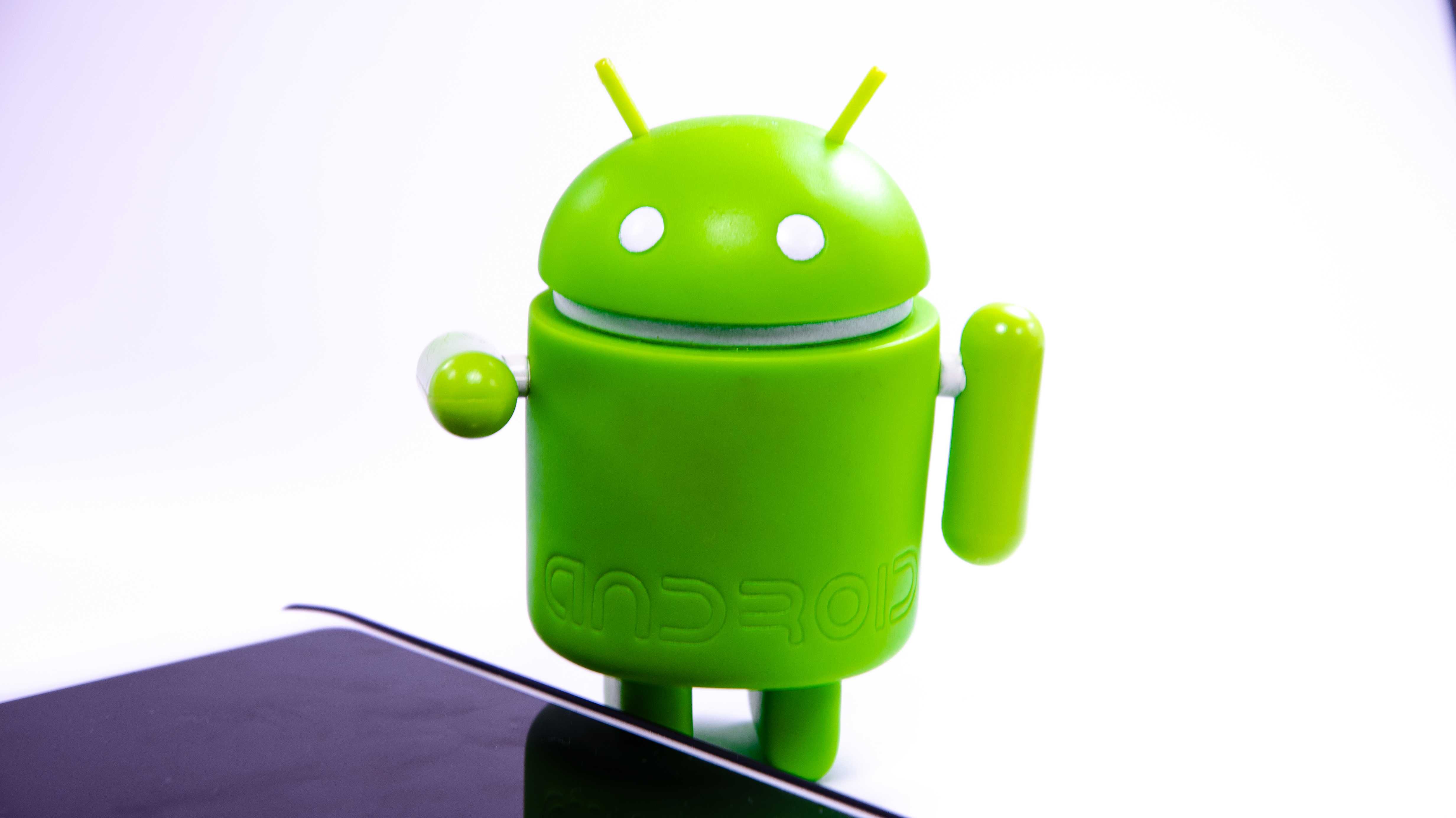 Grüner Androide, davor liegt ein Handy