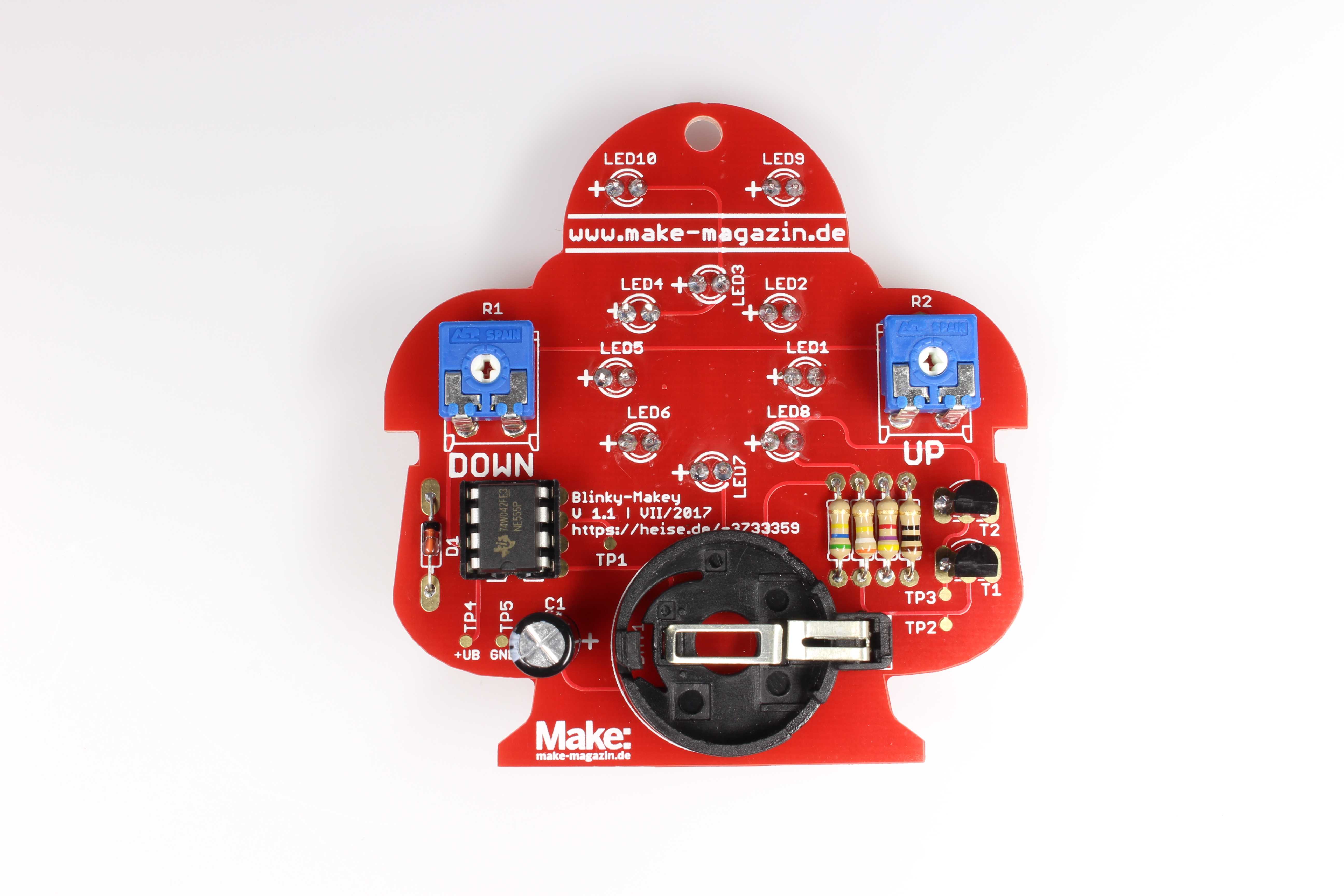 Löt-Makey von hinten: Eine rote Platine in Roboterform mit Lötstellen