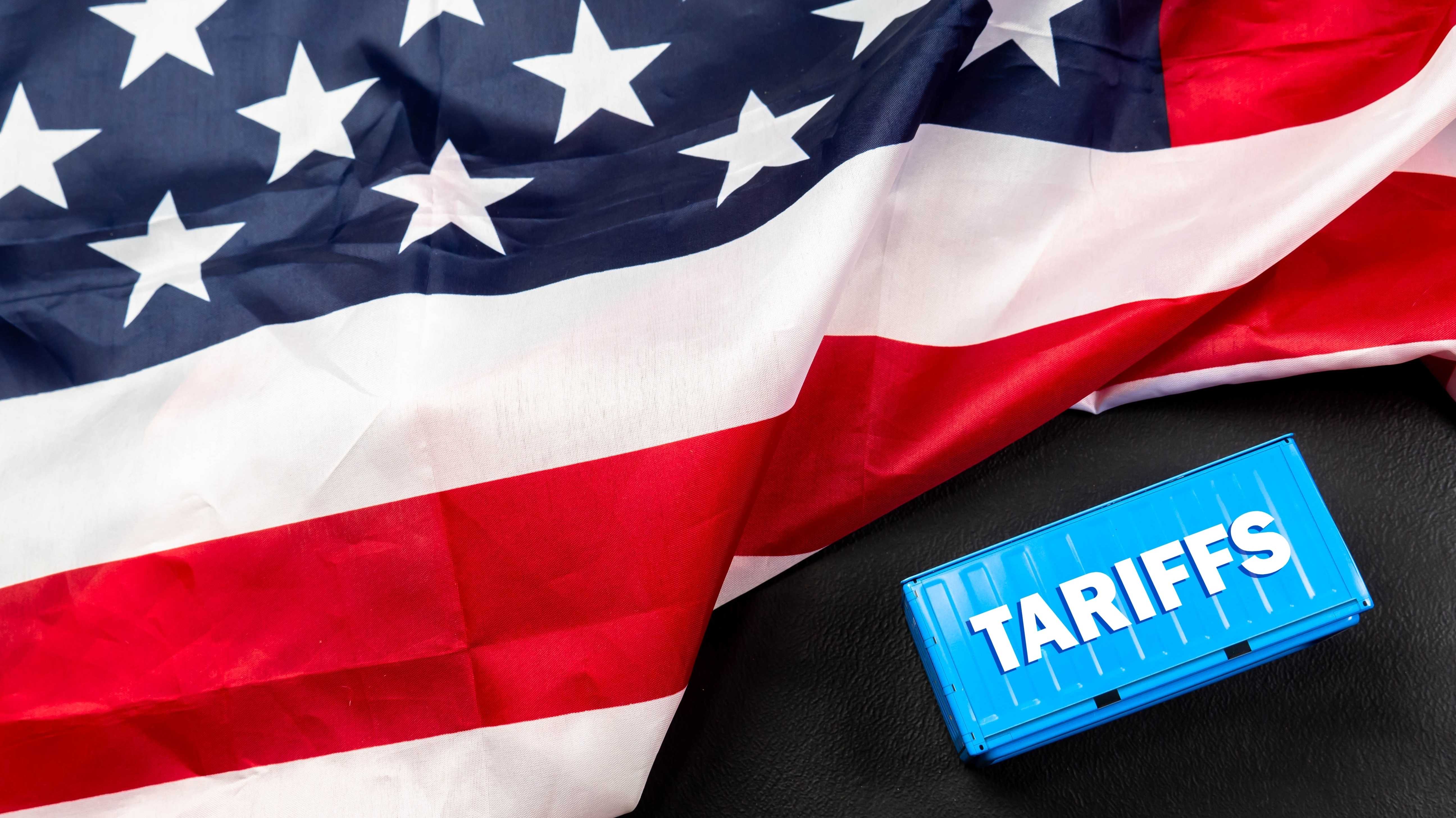 Container-Tarife vor dem Hintergrund der Flagge der Vereinigten Staaten von Amerika. Donald Trumps Politik, USA-Handelskrieg mit dem Begriff „Krise”.