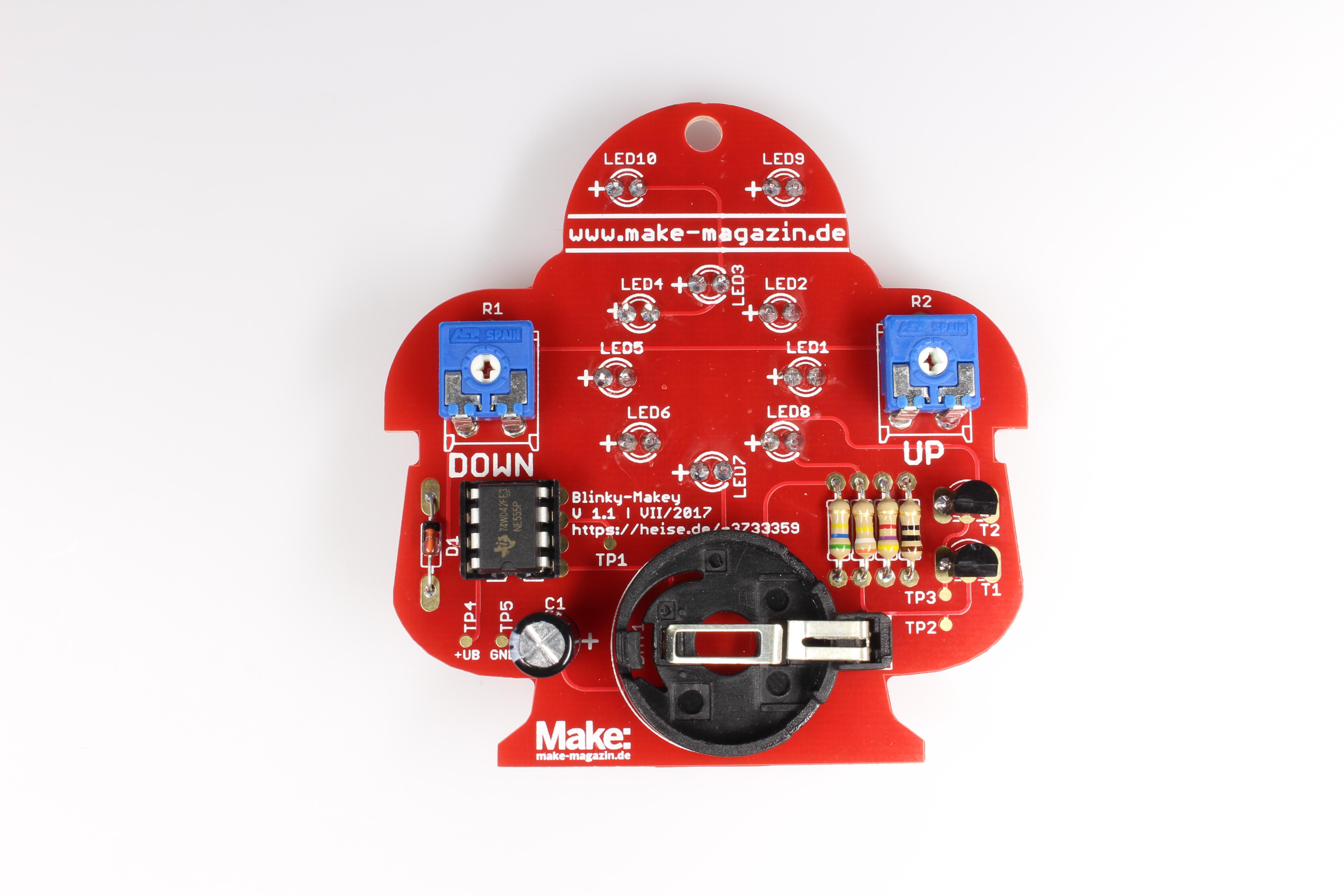 Löt-Makey von hinten: Eine rote Platine in Roboterform mit Lötstellen