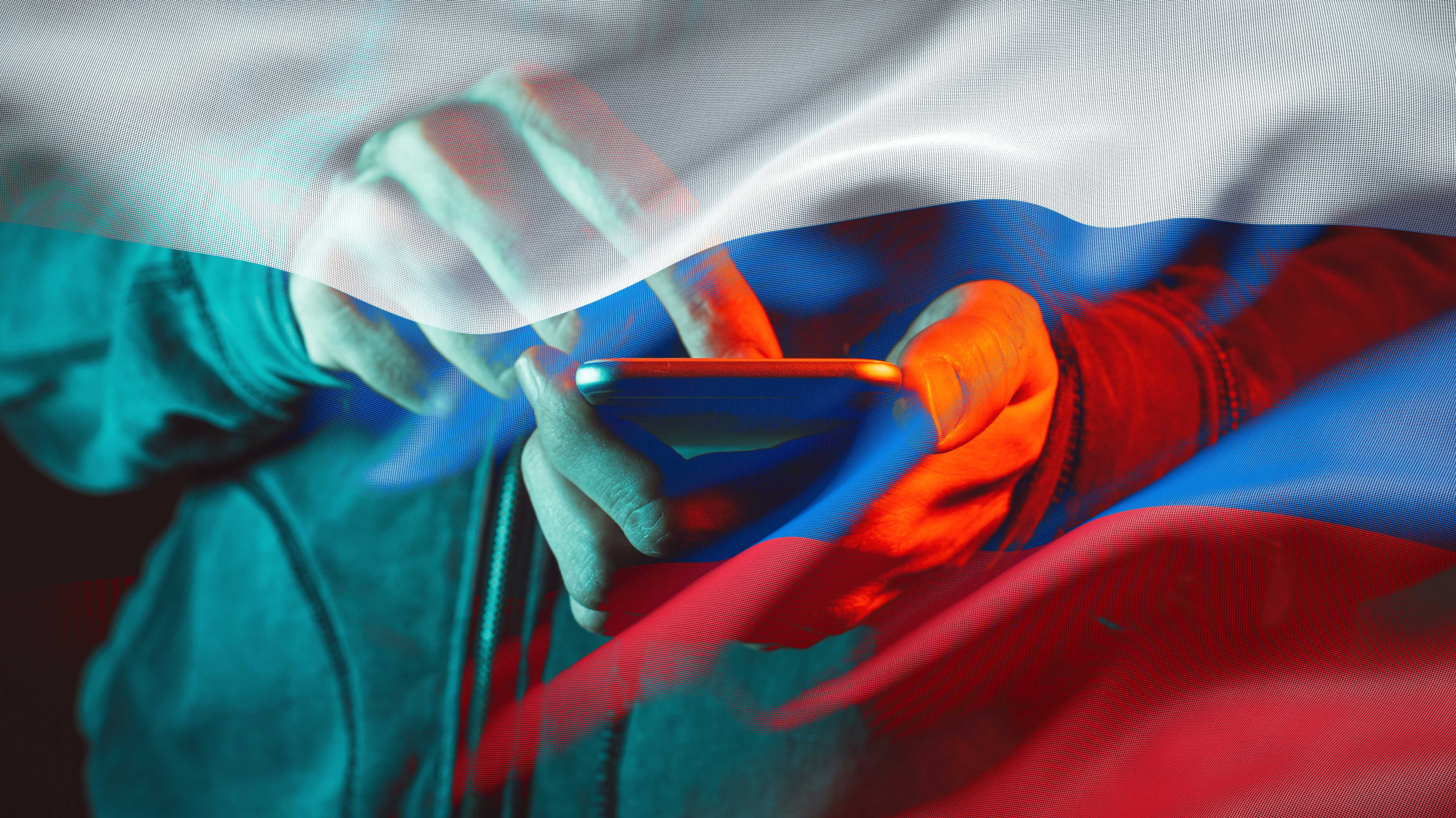 Hand am Smartphone hinter rusisscher Flagge