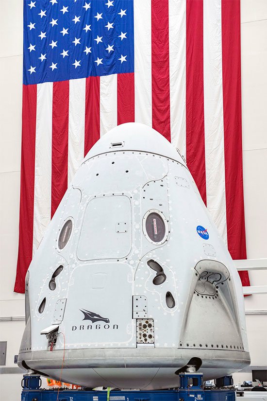 Raumkapsel Crew Dragon, dahinter US-Flagge
