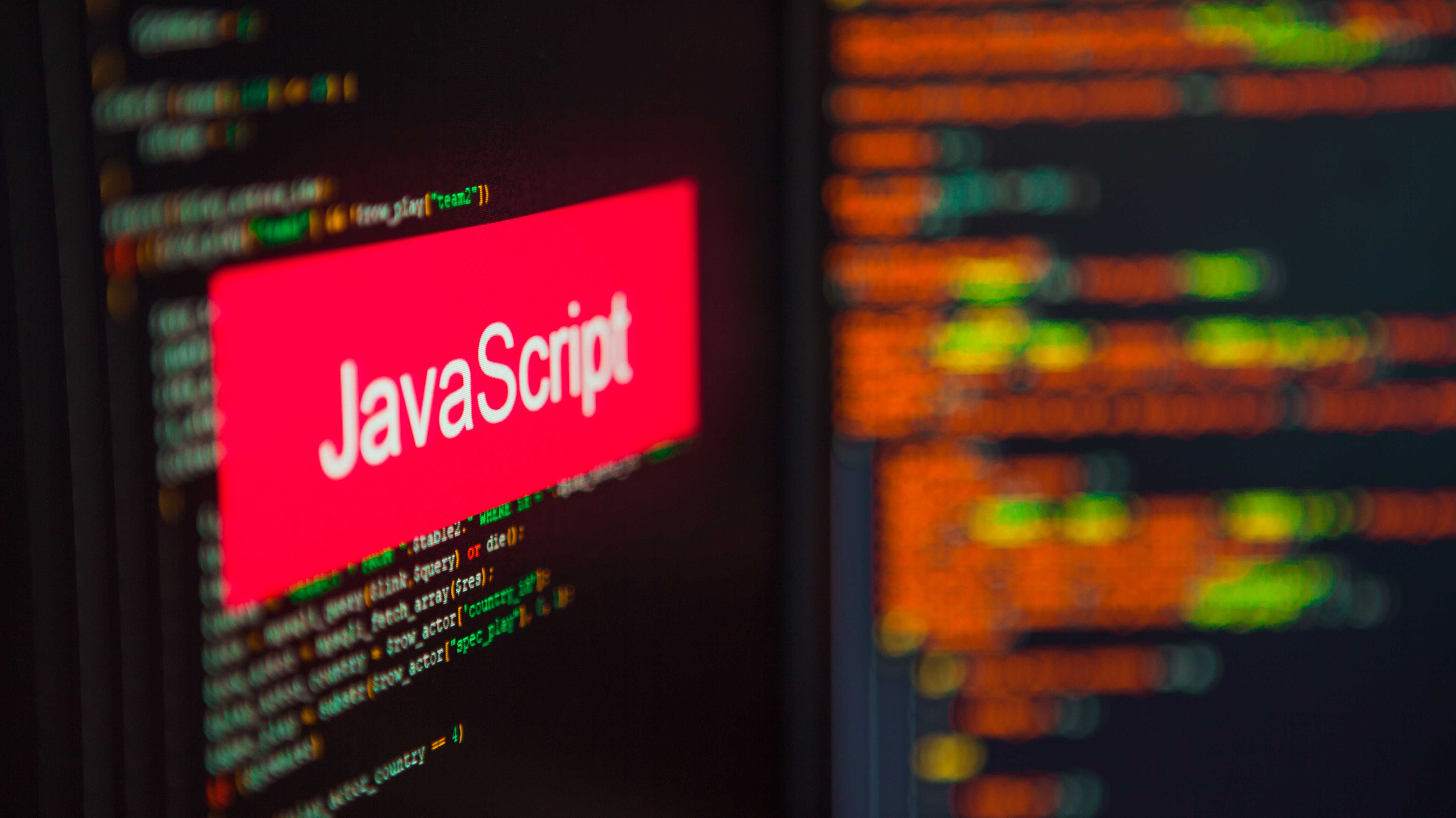 Ein Display mit verschwommenen Codezeilen, über denen ein roter Balken mit dem Schriftzug "Javascript" liegt.