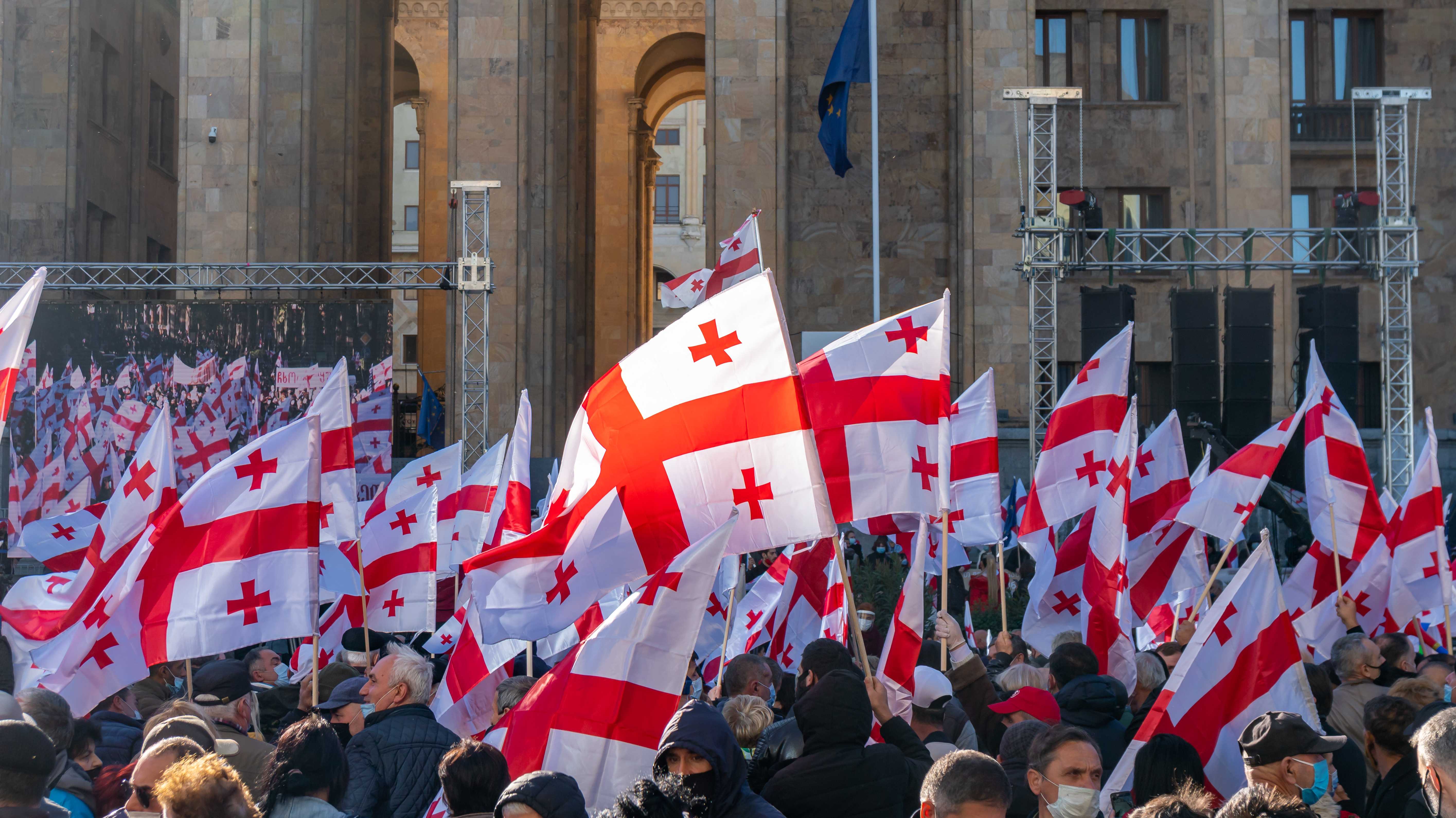 Demonstration mit georgischen Fahnen, weiß mit roten Kreuzen.