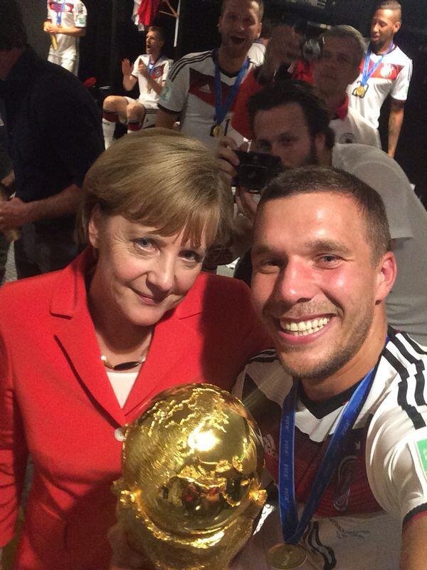 Lukas Podolski nahm sich, den WM-Pokal und die Bundeskanzlerin mit auf ein Foto