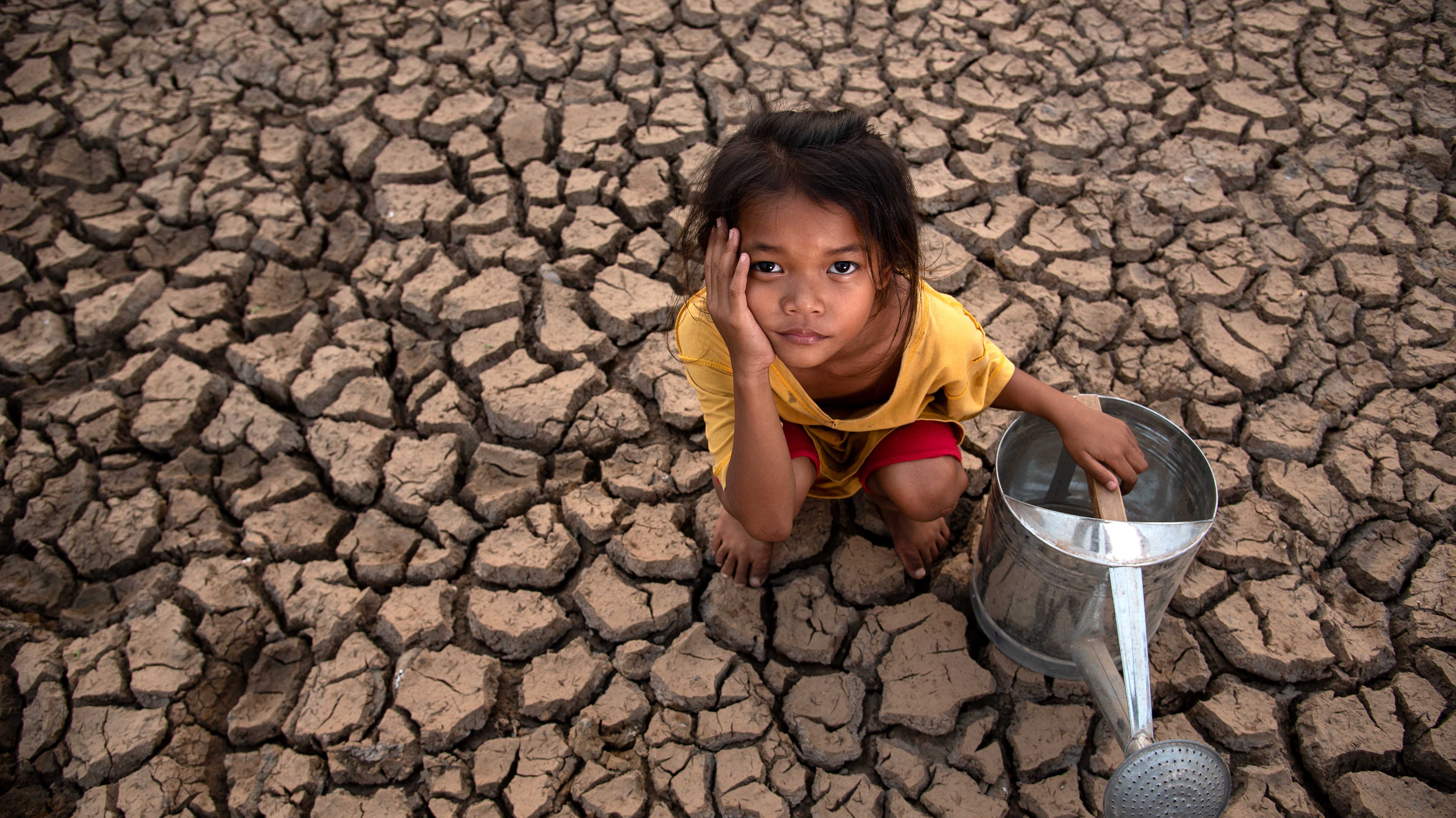 Kind in Asien auf verdorrtem Boden