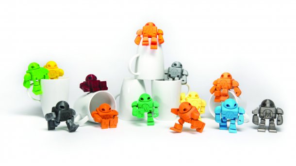 Viele bunte Roboter aus dem 3D-Drucker stehen neben- und übereinander.