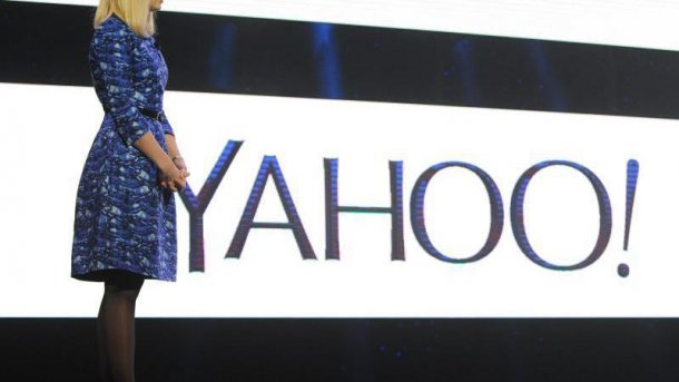 Marissa Mayer im Ganzkörperprofil neben Yahoo-Logo