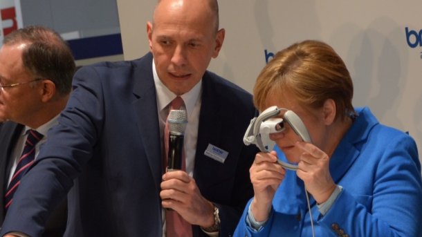 Merkel begutachtet Datenbrille von Brother