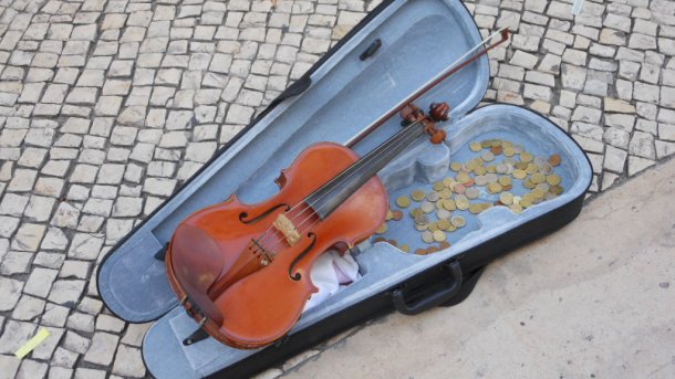 Geigenkasten mit Violine und vielen Münzen