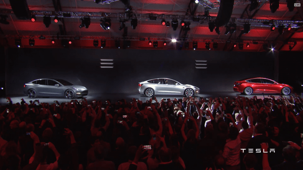 Drei Tesla Model 3 auf einer Bühne