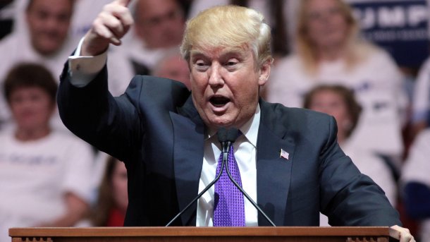Donald Trump an Rednerpult mit ausgestrecktem Zeigefinger