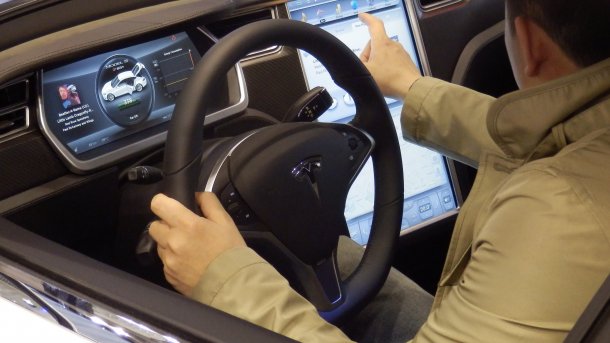 Ein Messebesucher nimmt das Cockpit des Tesla S in Augenschein.