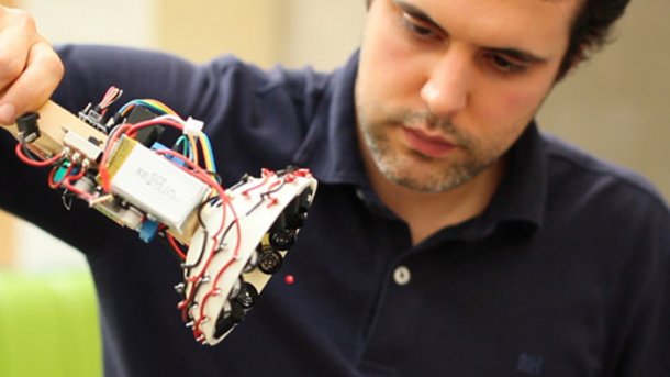 Ein Mann hält ein Gerät mit vielen Kabeln, das an eine Taschenlampe erinnert