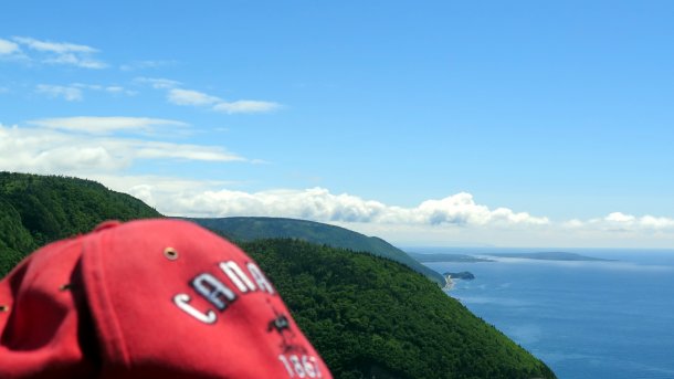 Küste Cape Bretons, davor Rote Kappe mit Aufschrift Canada est. 1867