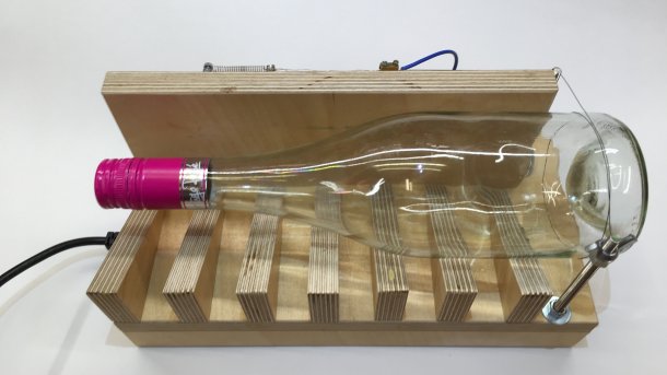 Eine durchsichtige Glasflasche auf einer Holz-Apparatur