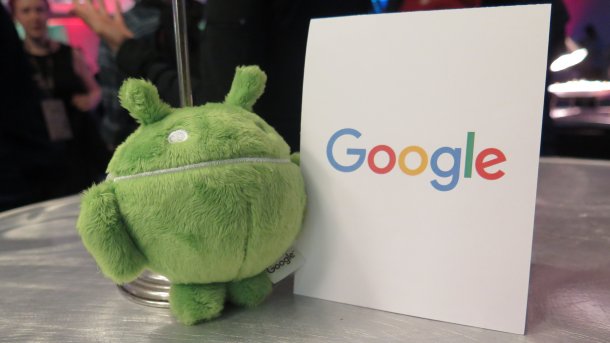 Plüsch-Androide neben Schild "Google"