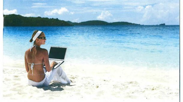 Fesche Dame mit Laptop am Strand