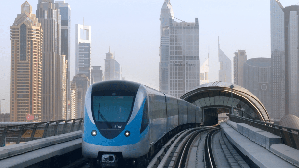 U-Bahn-Zug auif Viadukt, dahinter die Skyline Dubais