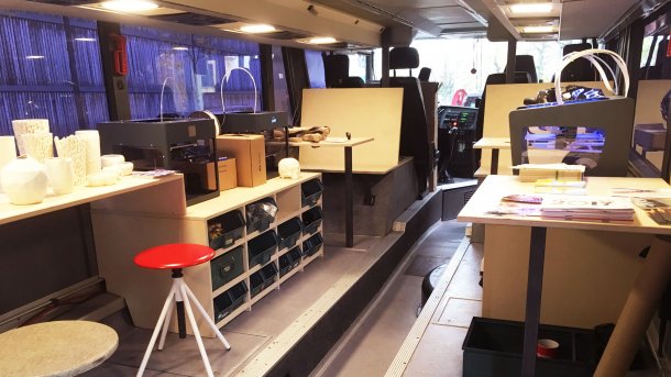 Umgebauter Bus, in dem innen Arbeitsplätze, 3D-Drucker und Regale stehen