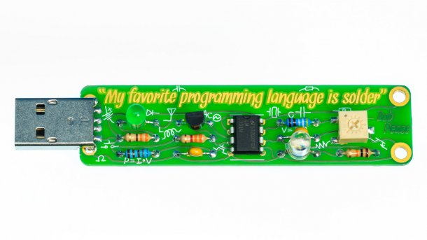 Grüner USB-Stick von Boldport mit aufgelötetem Bauteilen und der Aufschrift "My favourite programming language is solder".